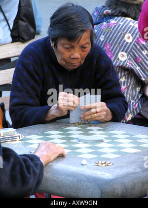 Donna anziana gioca carte in Chinatown, USA, Manhatten, Chinatown, New York Foto Stock