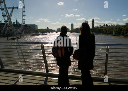 Due donne in piedi sul ponte sul Fiume Tamigi guardando lo skyline di Londra Foto Stock