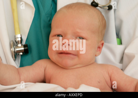 Medico detiene una bambina durante un esame fisico la determinazione di lei è una sana bambina. Foto Stock