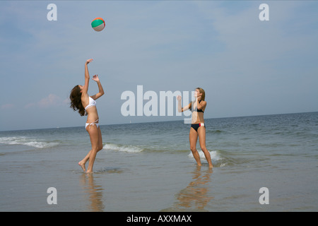 Due giovani donne giocando a pallavolo in spiaggia Foto Stock