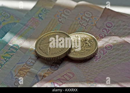 Due monete sterlina seduti sulla selezione di sterling note Foto Stock