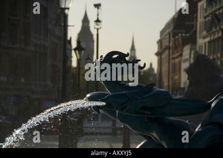 Dettaglio di una fontana di acqua scultura in Trafalgar Square guardando verso il Big Ben giù Whitehall Foto Stock