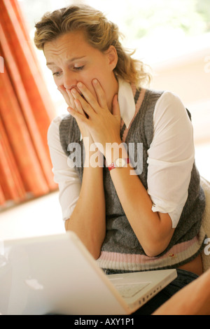 Turbare la donna utilizzando laptop Foto Stock