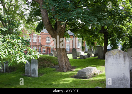 Le lapidi nel sagrato della chiesa della Santa Trinità con edifici del periodo in background. Guildford Surrey, Inghilterra. Foto Stock