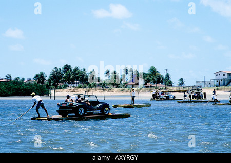 Una sola spiaggia-buggy è punted attraverso una laguna poco profonda su un jangada verso le dune di Genipabu vicino a Natal, Brasile Foto Stock