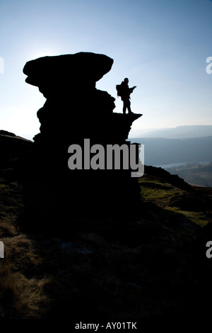 Una silhouette di un walker in piedi su la cantina di sale sul bordo Derwent nel Derbyshire. Foto Stock