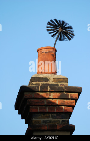 Edifici con spazzacamini spazzola prenderci al di fuori del vecchio camino Foto Stock