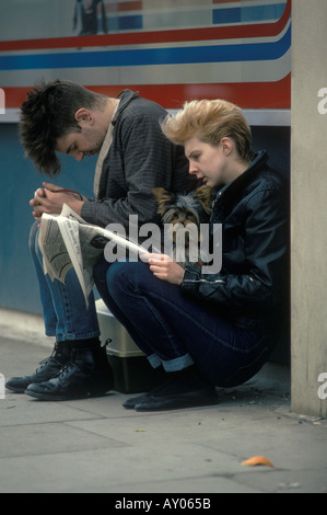 Adolescenti degli anni '1980 Regno Unito. Coppia punk che legge giornali che tengono in mano il loro cane domestico. Londra Inghilterra. HOMER SYKES Foto Stock