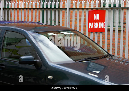 Blu scuro auto parcheggiate davanti a un rosso nessun segno di parcheggio attaccata alla porta di metallo nel quartiere della Cattedrale di Belfast City Centre Foto Stock