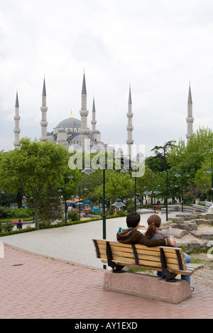 Un giovane seduto su una panchina, ammirando la vista della Moschea Blu di Istanbul, Turchia Foto Stock