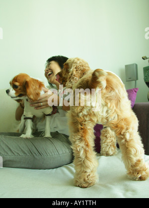 Close-up di una donna matura seduti e tenere due cani Foto Stock