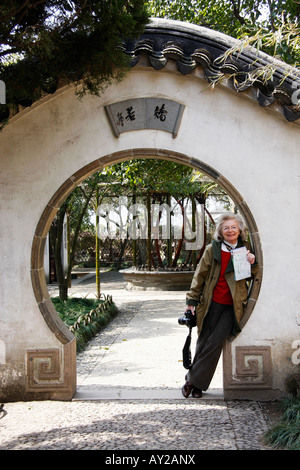 Porta la luna con un turista appoggiata contro la parete in umile Giardino gli amministratori a Suzhou,Cina Foto Stock