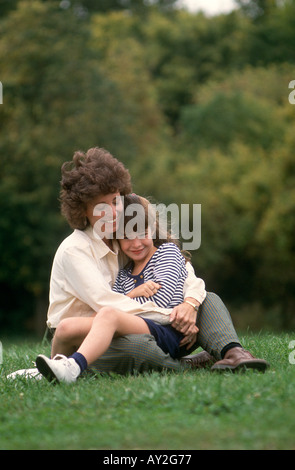 Mamma e figlia abbraccio seduti su erba nel Parco delle Rose in Columbus Ohio USA Foto Stock