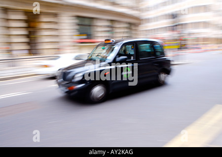 Londra taxi con motion blur accelerando attraverso le strade Foto Stock