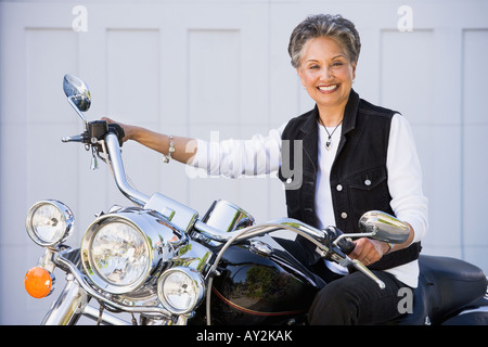 Senior americano africano donna seduta sul motociclo Foto Stock