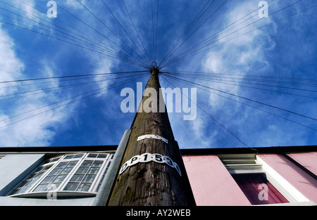 Un palo del telegrafo con un web di linee che promana dalla sua sommità sorge nella parte anteriore del tetto a terrazza di case vittoriane in Brighton Foto Stock