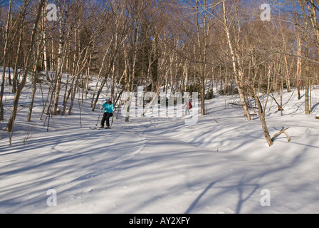 Due donne su sci alpino su uno sci backcountry viaggio su un soleggiato tardo inverno del giorno in Gerusalemme Vermont Foto Stock