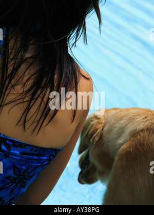 Metà vista in sezione di una giovane donna con un golden retriever cane a bordo piscina Foto Stock