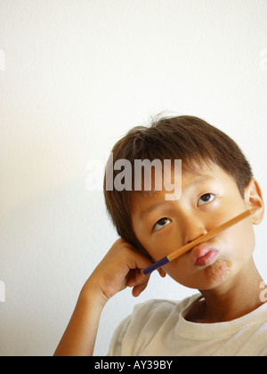 Ragazzo tenendo un pennello sulla sua bocca Foto Stock