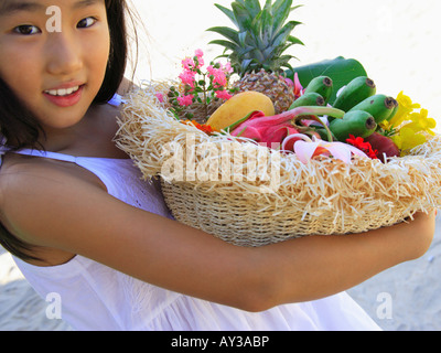 Ritratto di una ragazza con un cesto pieno di frutta e fiori Foto Stock