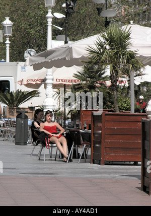 Donna in abito rosso a Sidewalk Cafe San Sebastian regione basca della Spagna Foto Stock