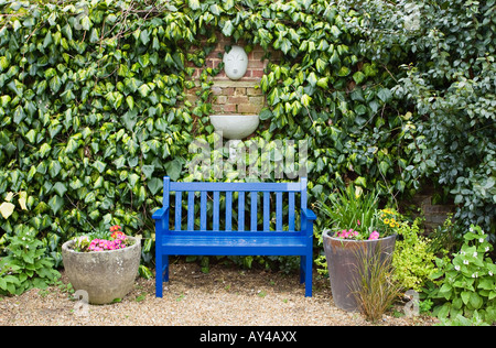 Il blu di legno verniciato giardino nel sedile anteriore della fontana a muro Foto Stock