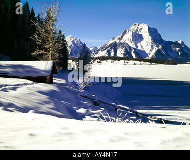 Nel Parco Nazionale di Grand Teton in Wyoming inverno nevica coprono una piccola cabina sulle rive del lago Jackson con torreggiante Monte Moran Foto Stock