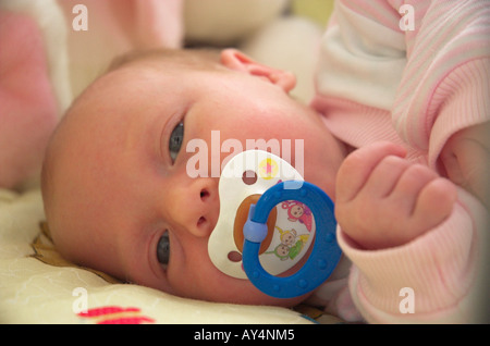 Neonato ragazza 0 3 mesi che giace nella mangiatoia con succhietto fino in prossimità della faccia Foto Stock