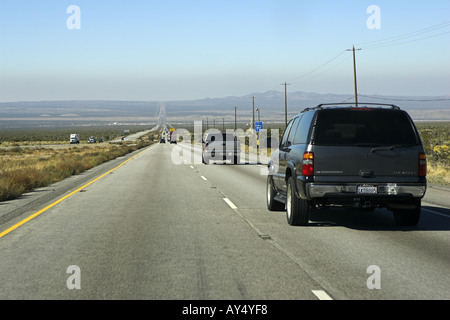 SUV e camion che guidano lungo diritto 2 corsie autostrada I95 Nevada USA. Vista di lunga, strada desertica dritto che si estende fino all'orizzonte Foto Stock