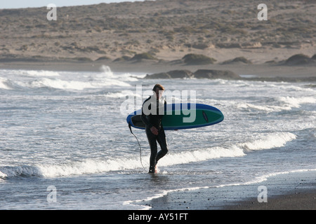 Surfer emerge dal mare dopo una sessione di surf a El Medano tenerife Foto Stock