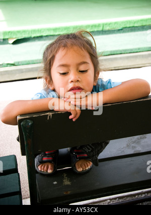 Giovane ragazza si siede su una panchina in Nuova Zelanda Foto Stock