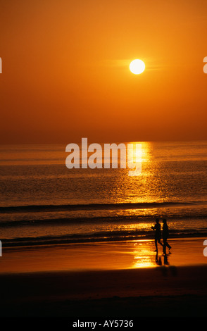 Giovane camminando lungo la spiaggia al tramonto " Costa de la Luz " Tarifa Provincia di Cadice Spagna Foto Stock