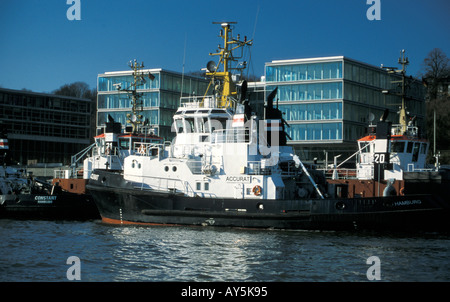 Il rimorchiatore a traino centrale di Neumuehlen nel porto di Amburgo, Germania; in background uffici moderni edifici lungo il fiume Elba Foto Stock