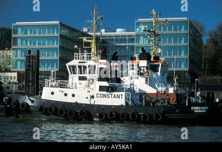 Il rimorchiatore a traino centrale di Neumuehlen nel porto di Amburgo, Germania; in background uffici moderni edifici lungo il fiume Elba Foto Stock