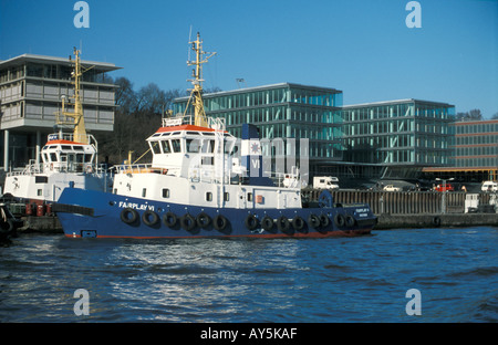 Il rimorchiatore a traino centrale di Neumuehlen nel porto di Amburgo, Germania; in background uffici moderni edifici lungo il fiume Elba Foto Stock