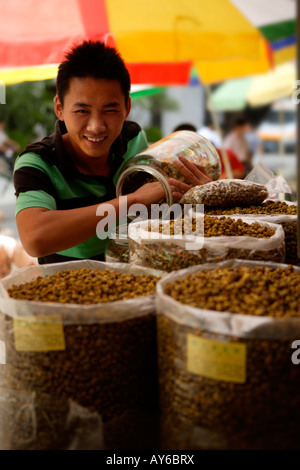 Titolare di stallo, mercato pacifica, Guangzhou, Cina (questo mercato è già tristemente noto per illegale il traffico di animali) Foto Stock