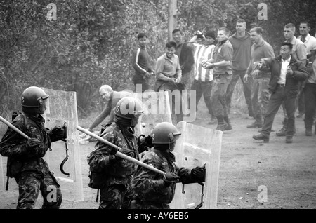 I soldati britannici dal Royal Gurkha fucili spostare in su rivoltosi Foto Stock