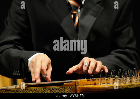 Close up di un musicista con le mani in mano la riproduzione qanun, un strumento orientali, durante una performance di profughi di guerra a Damasco, Siria Foto Stock