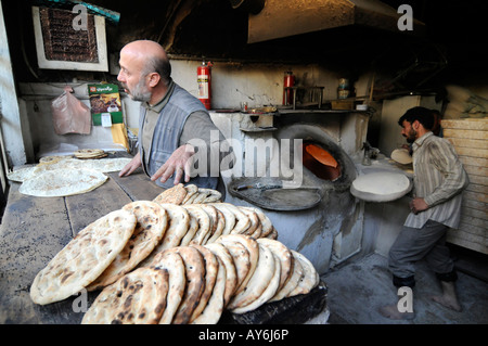 Un baker rendendo tradizionale araba pane piatto in Damasco, Siria. Foto Stock