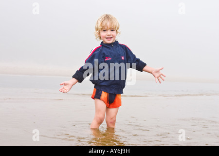 Ragazzo biondo sulla spiaggia misty, Lielupe, Lettonia Foto Stock