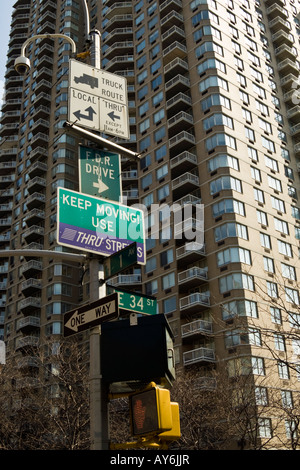 Lightpost con segni attaccati in corrispondenza di un angolo di 1° Avenue e la 34th Street a New York City Foto Stock