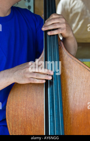 Chiusura del violoncello e mani spiumatura stringhe; pizzicato metodo di riproduzione spiccando le stringhe con le dita anziché con archetto Foto Stock