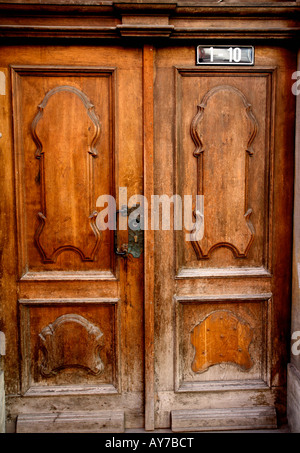 Doppie porte in legno con pannelli scolpiti nella parte anteriore, peeling vernice dal bordo inferiore Foto Stock