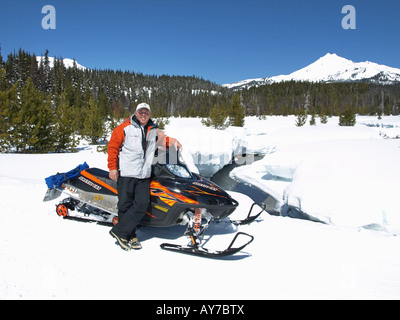 Un snowmobiler teste per Elk Lake Resort da Mount Bachelor Ski Area lungo la cascata Autostrada dei Laghi Foto Stock