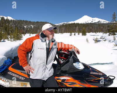 Un Snowmobiler teste per Elk Lake Resort da Mount Bachelor Ski Area lungo la cascata Autostrada dei Laghi Foto Stock