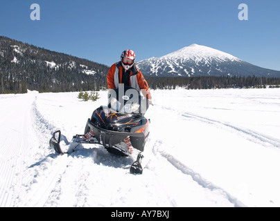 Un snowmobiler teste per Elk Lake Resort da Mount Bachelor Ski Area lungo la cascata Autostrada dei Laghi Foto Stock