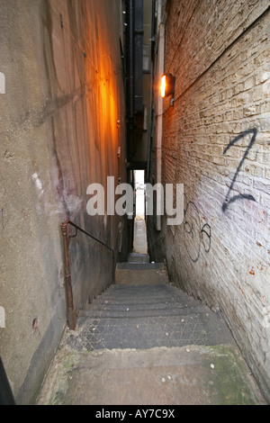 Ampia angolazione del vicolo stretto con gradini che conducono giù sulla strada. Foto Stock