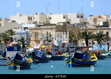 Piccole barche da pesca chiamato Luzzu nel porto di Marsaxlokk a Malta Foto Stock