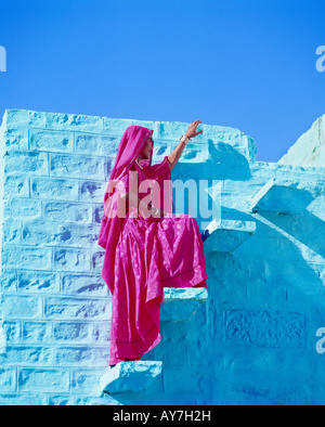 La donna in un villaggio salendo le scale, Rajasthan, India Foto Stock