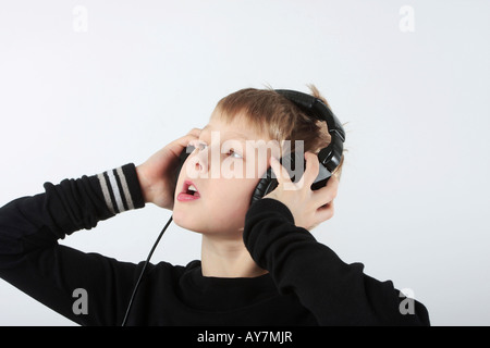Ragazzo giovane ascoltando la musica nelle cuffie Foto Stock